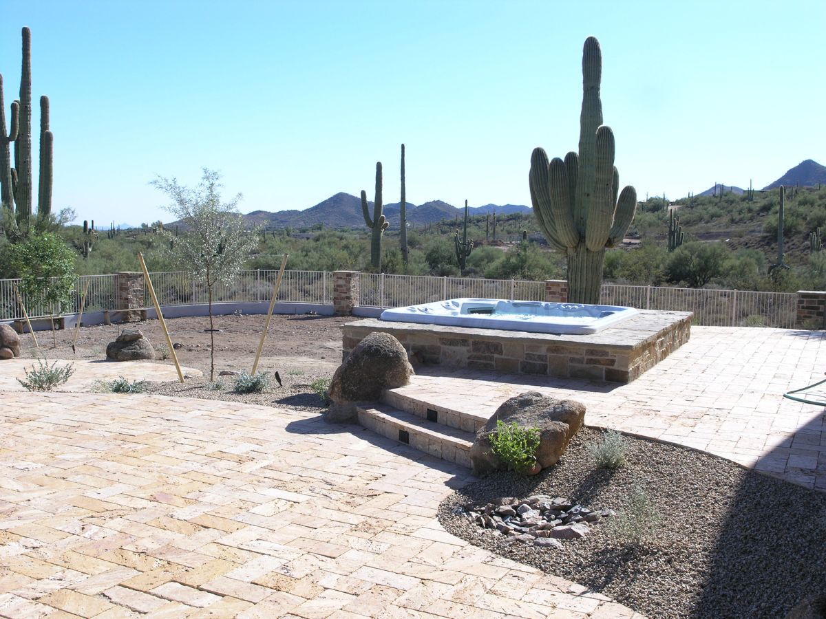 Arizona desert patio with stone pavers, built-in hot tub spa, saguaro cacti and scenic mountain views