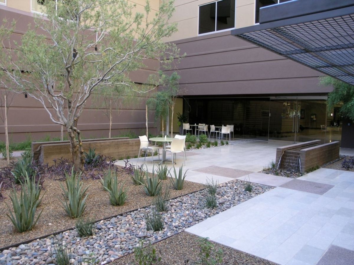 Modern office courtyard with desert landscaping, agave plants, patio seating and a reflecting water feature