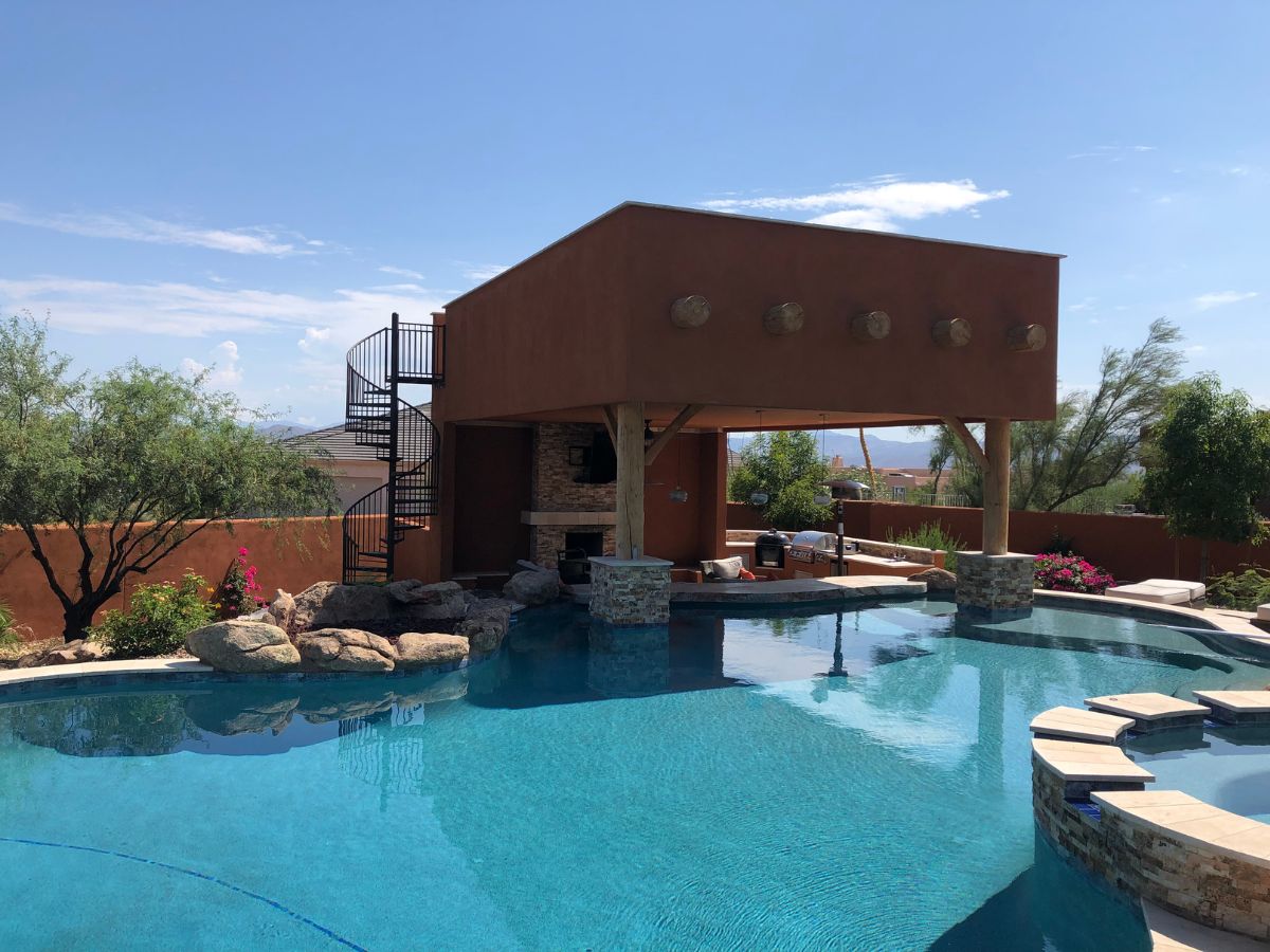 Luxury backyard pool with swim-up bar, spa, rock waterfall and spiral staircase to rooftop cabana