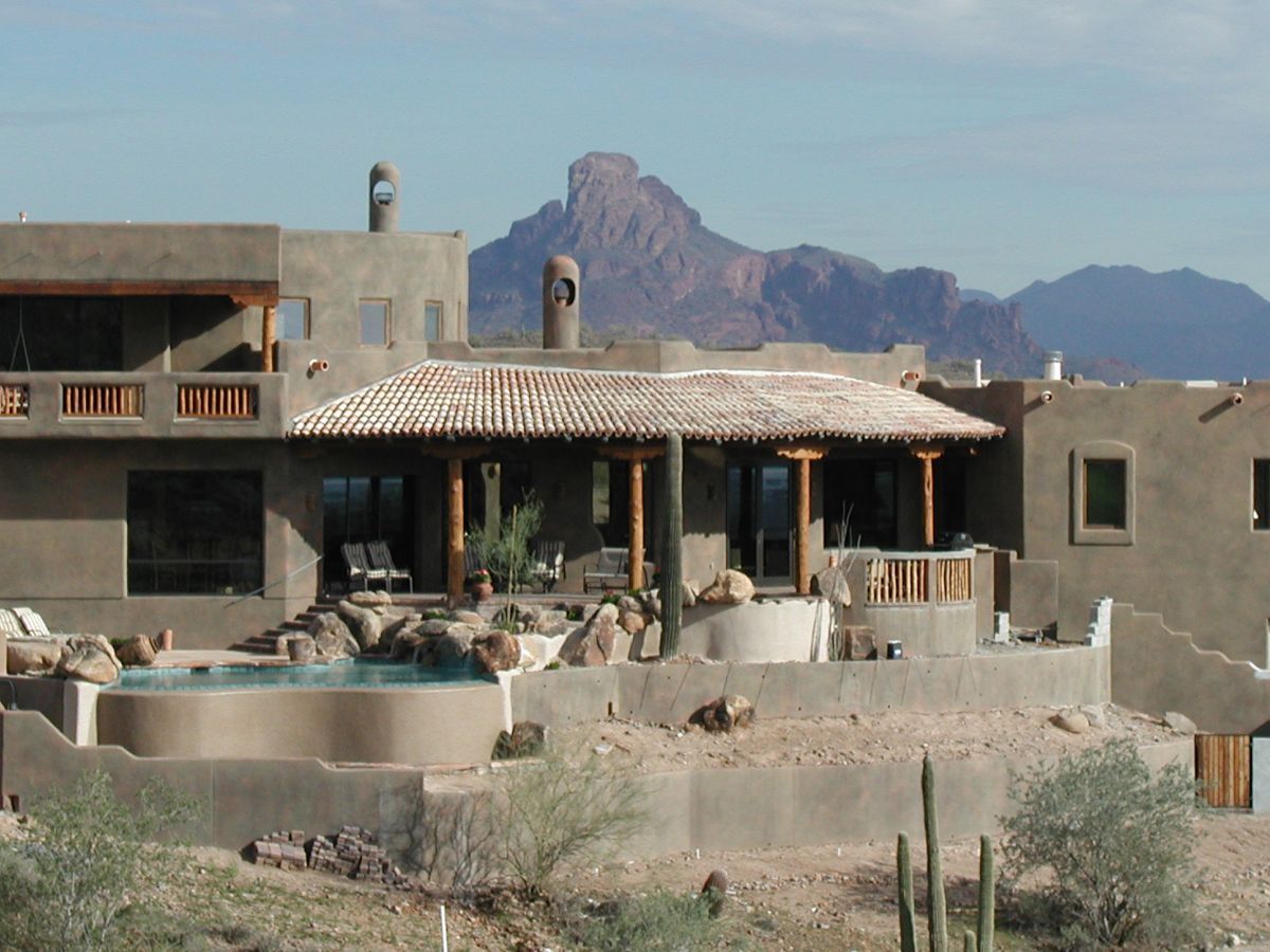 Southwestern adobe-style desert villa with tiled patio, plunge pool, saguaro cacti and rugged mountain backdrop