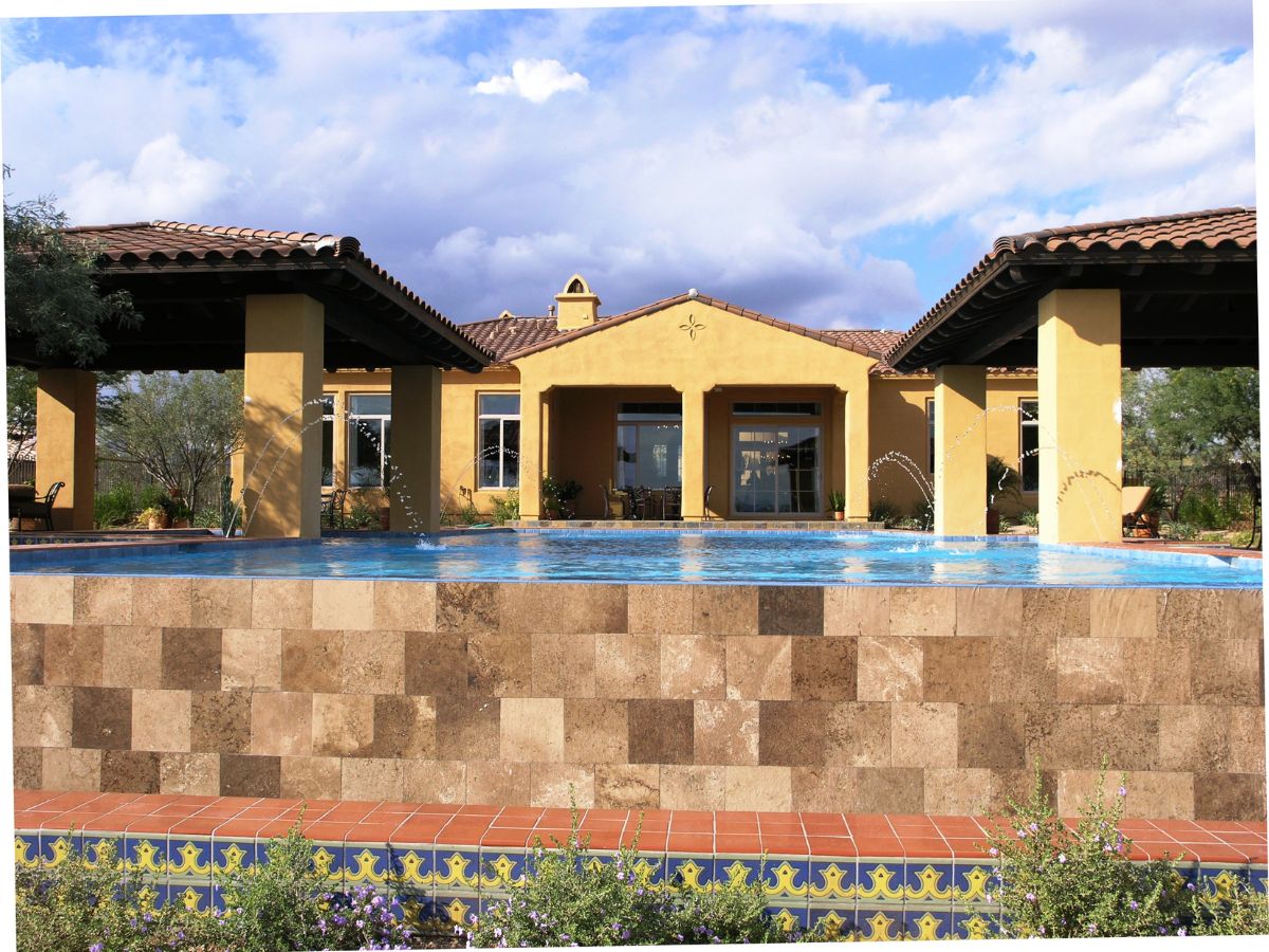 Luxury Mediterranean villa with infinity pool, tiled stone pool wall, terracotta roof and fountain jets